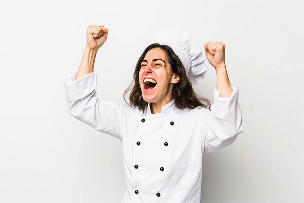 Young Brazilian chef woman celebrating a victory in winner position on white isolated background