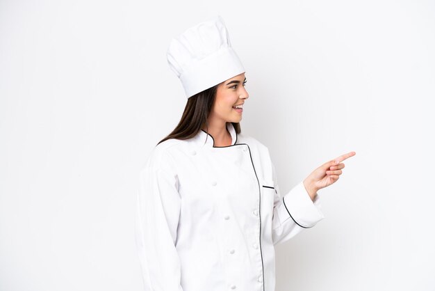 Young Brazilian chef woman isolated on white background pointing finger to the side and presenting a product