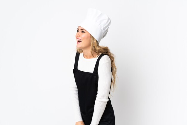 Young Brazilian chef woman isolated on white laughing in lateral position