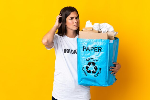 Young brazilian girl holding a recycling bag full of paper to recycle isolated