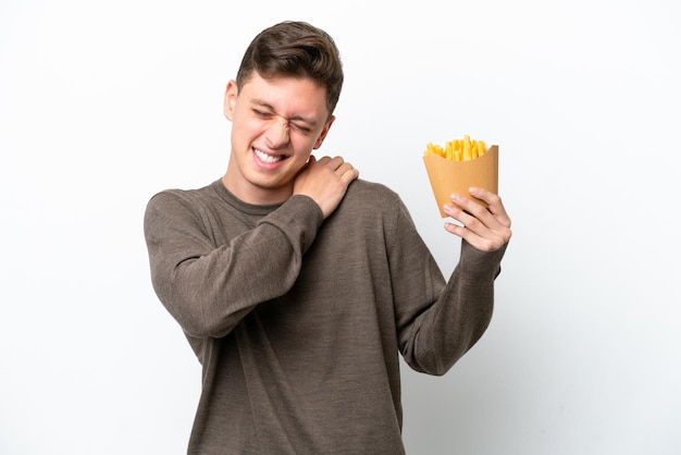 Giovane brasiliano che tiene patatine fritte isolate su sfondo bianco che soffre di dolore alla spalla per aver fatto uno sforzo