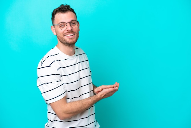 Young Brazilian man isolated on blue background applauding