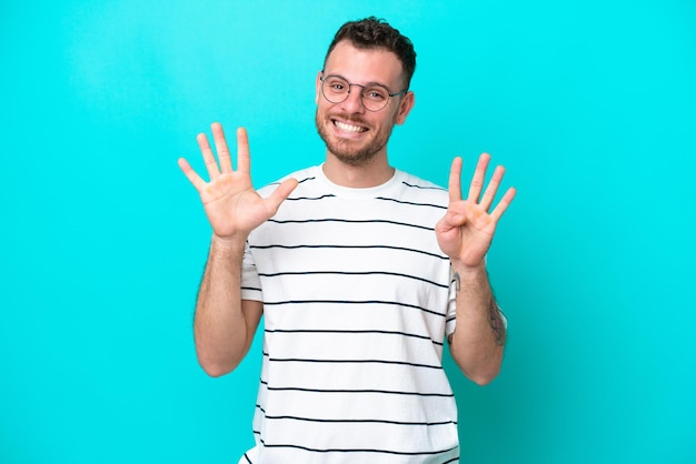 Young Brazilian man isolated on blue background counting nine with fingers