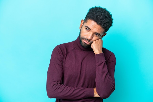 Photo young brazilian man isolated on blue background with tired and bored expression