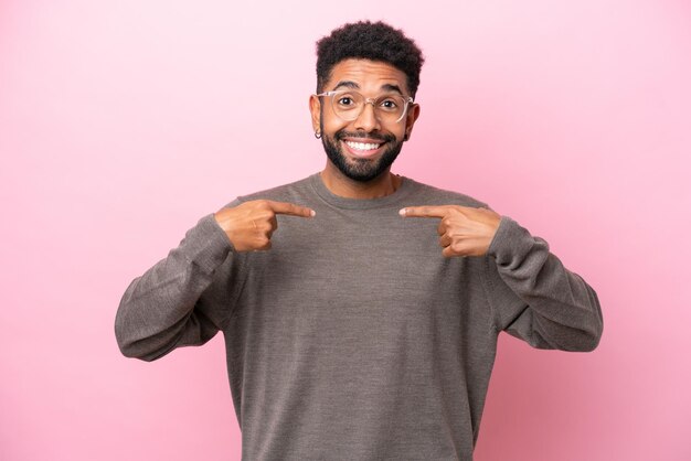 Young Brazilian man isolated on pink background with surprise facial expression