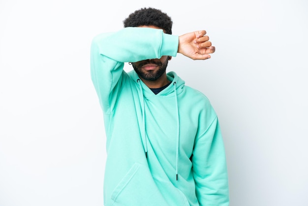 Young Brazilian man isolated on white background covering eyes by hands