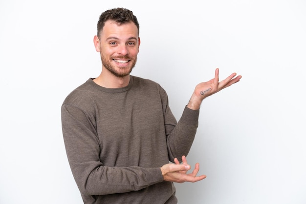 Young Brazilian man isolated on white background extending hands to the side for inviting to come