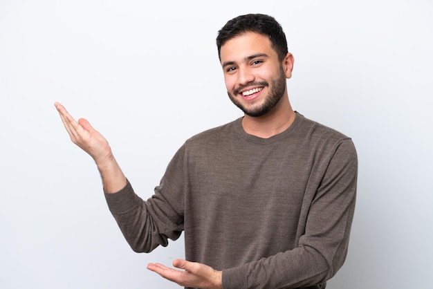 Young Brazilian man isolated on white background extending hands to the side for inviting to come