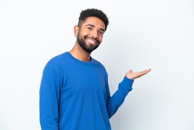 Young Brazilian man isolated on white background extending hands to the side for inviting to come