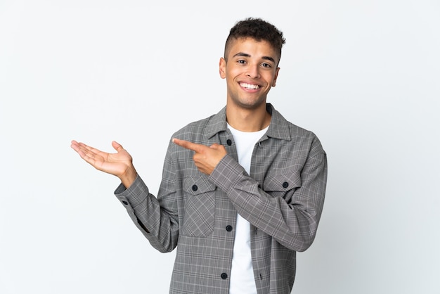 広告を挿入するために手のひらに架空のコピースペースを保持している白い背景で隔離の若いブラジル人男性