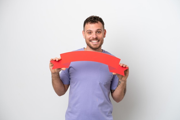 Young Brazilian man isolated on white background holding an empty placard