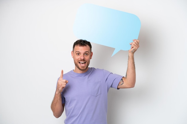 Young Brazilian man isolated on white background holding an empty speech bubble with surprised expression