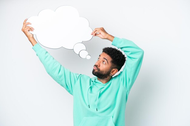 Photo young brazilian man isolated on white background holding a thinking speech bubble