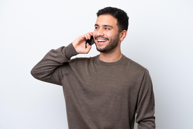 携帯電話との会話を維持する白い背景に分離された若いブラジル人男性