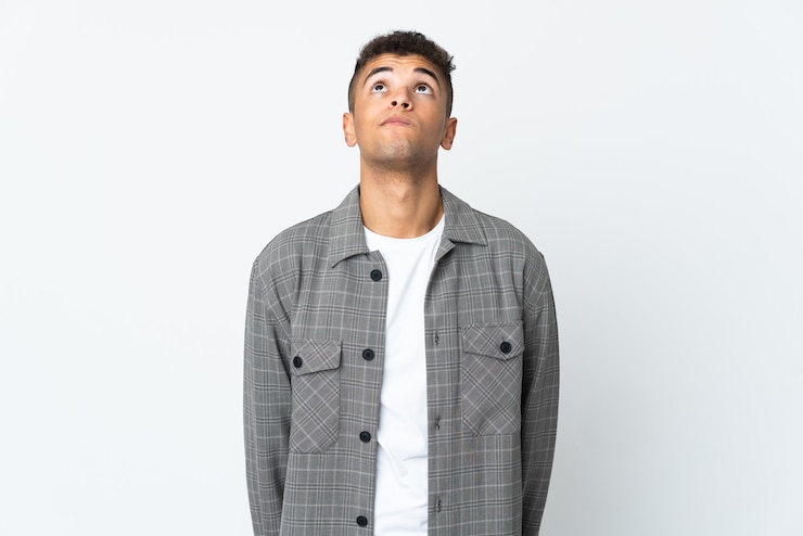 Photo young brazilian man isolated on white wall and looking up