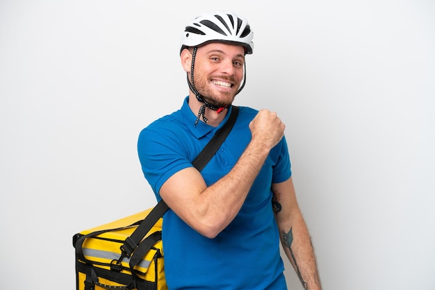 Young brazilian man with thermal backpack isolated on white background celebrating a victory