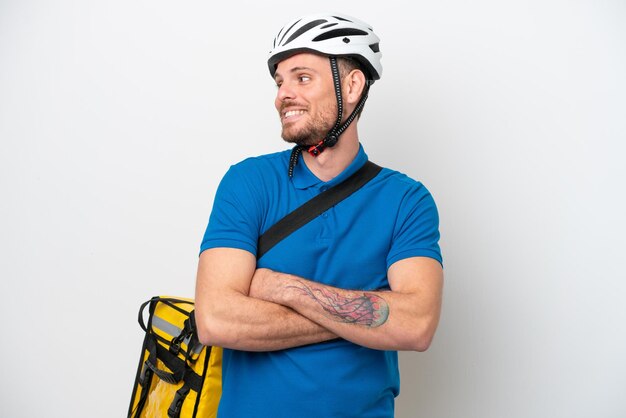 Young brazilian man with thermal backpack isolated on white background looking side