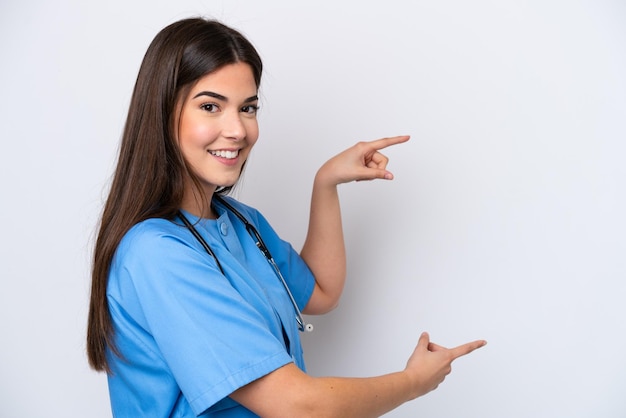 Young brazilian nurse woman isolated on white background pointing finger to the side and presenting a product