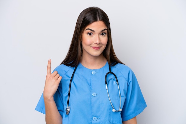 Young Brazilian nurse woman isolated on white background pointing with the index finger a great idea