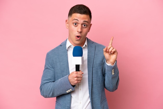 Young brazilian presenter man isolated on pink background intending to realizes the solution while lifting a finger up