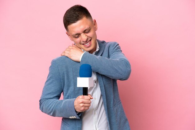 Young brazilian presenter man isolated on pink background suffering from pain in shoulder for having made an effort