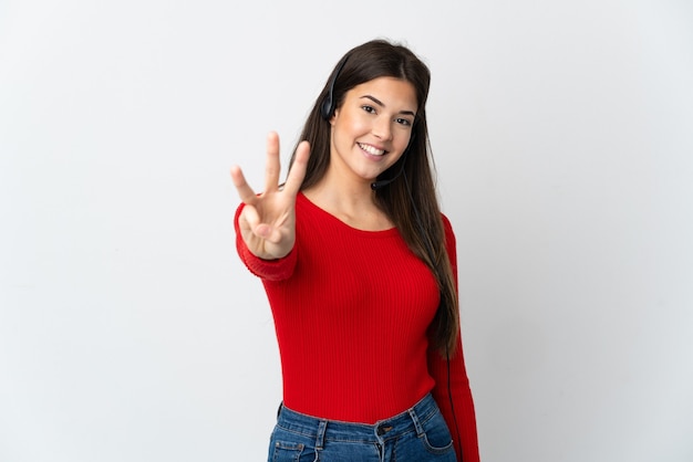 Молодая бразильская девушка телемаркетинга на изолированном фоне счастлива и считает три пальцами