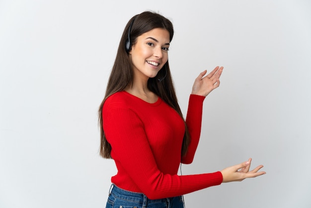 Young Brazilian telemarketer girl over isolated wall extending hands to the side for inviting to come