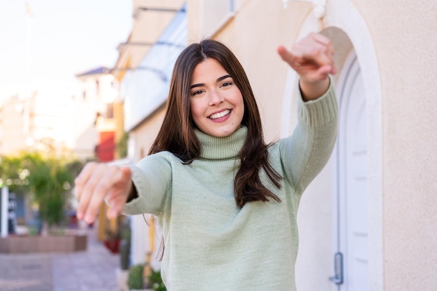 写真 屋外で若いブラジル人女性が微笑みながらあなたに指を向ける