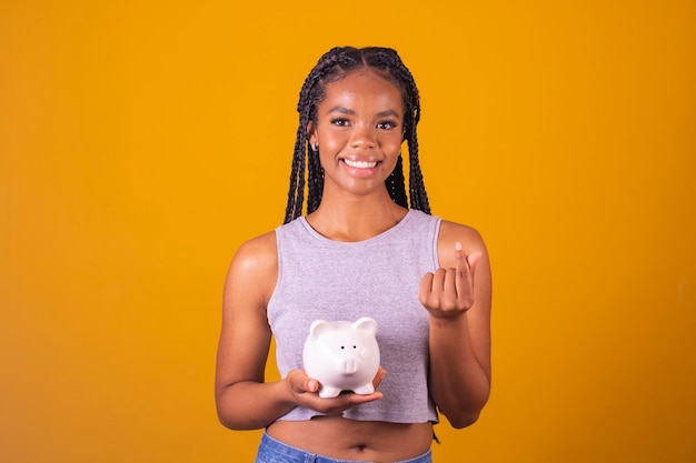 Young Brazilian woman holding piggy bank and coin concept of economy finance saving