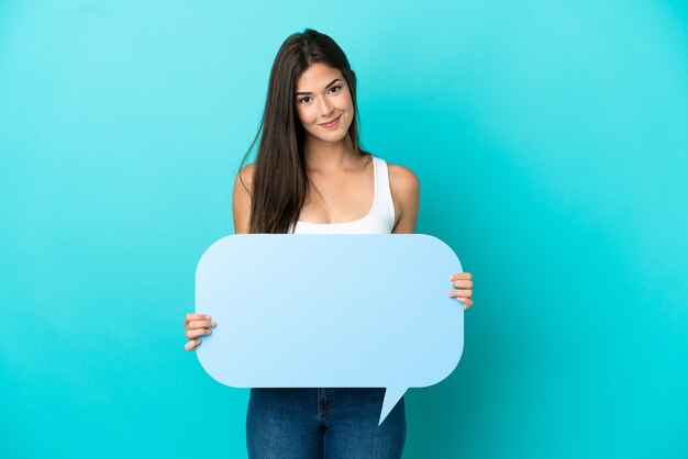 Young Brazilian woman isolated on blue background holding an empty speech bubble