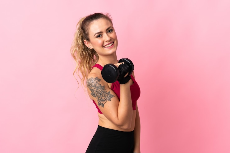 Photo young brazilian woman isolated on pink making weightlifting
