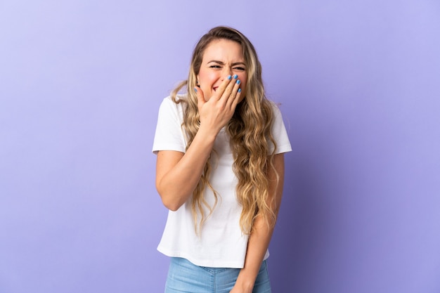 Giovane donna brasiliana isolata sulla bocca della copertura felice e sorridente viola con la mano