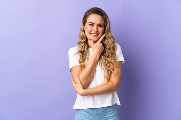 Young Brazilian woman isolated on purple happy and smiling