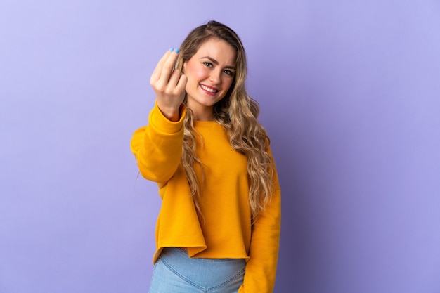 Young Brazilian woman isolated on purple  making money gesture