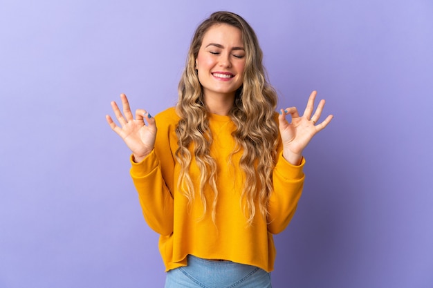 Young Brazilian woman isolated on purple  in zen pose