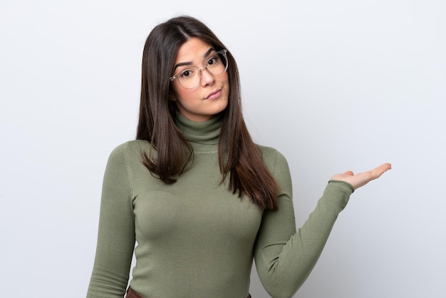 Young Brazilian woman isolated on white background having doubts