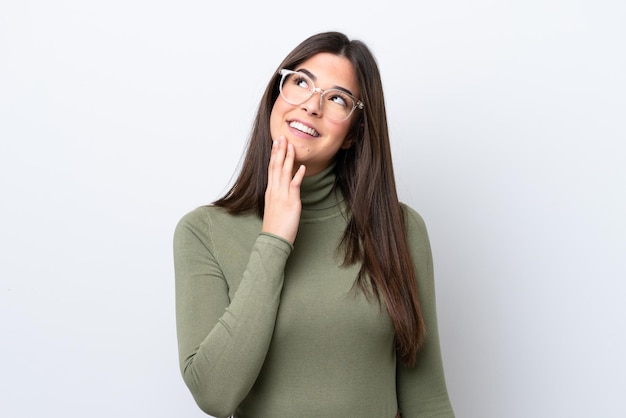 Young Brazilian woman isolated on white background looking up while smiling