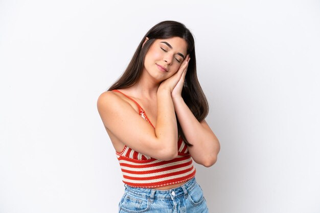 Young Brazilian woman isolated on white background making sleep gesture in dorable expression