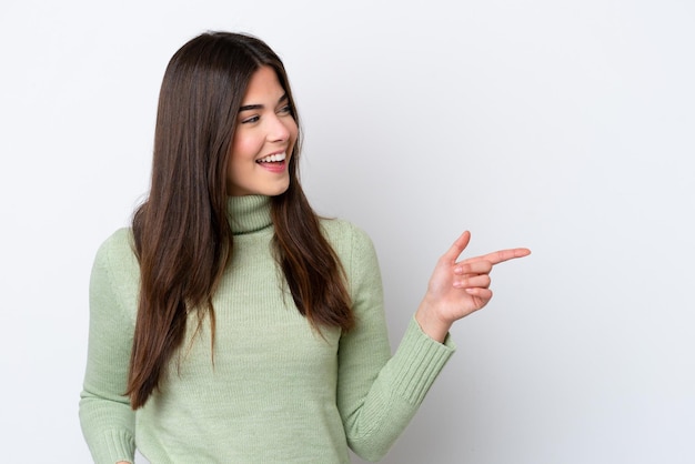 Young Brazilian woman isolated on white background pointing finger to the side and presenting a product