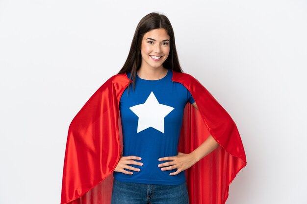 Photo young brazilian woman isolated on white background in superhero costume posing with arms at hip and smiling