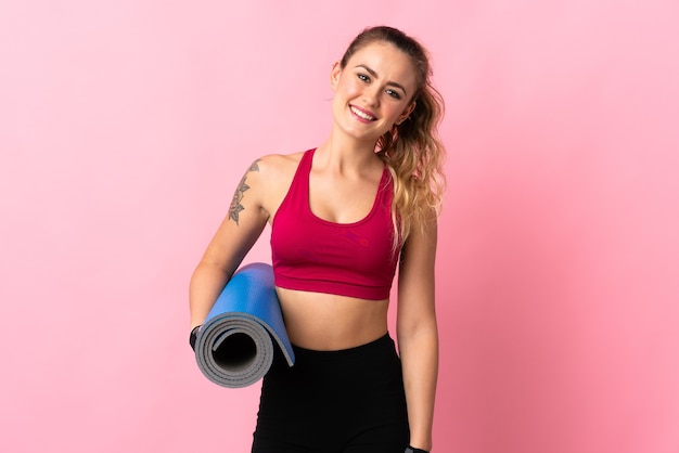 Young Brazilian woman isolated with a mat and smiling