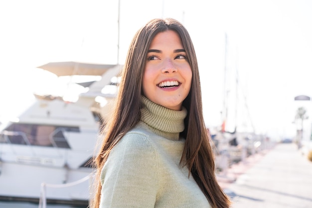 Young Brazilian woman at outdoors With happy expression