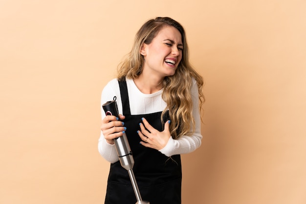 Young brazilian woman using hand blender isolated