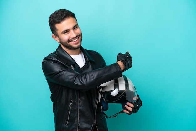 Young Brazilian woman with a motorcycle helmet isolated on blue background pointing back