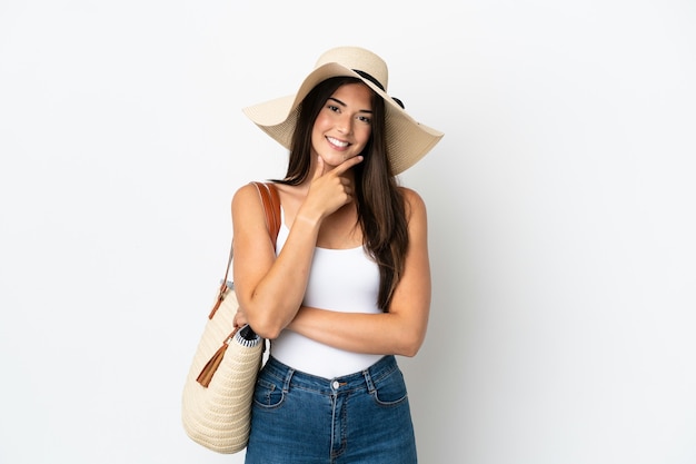 Young Brazilian woman with Pamela holding a beach bag isolated on white background smiling