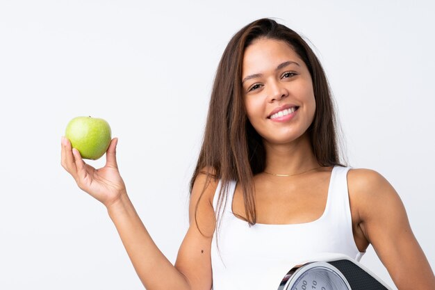 Young Brazilian woman with a scale and an apple