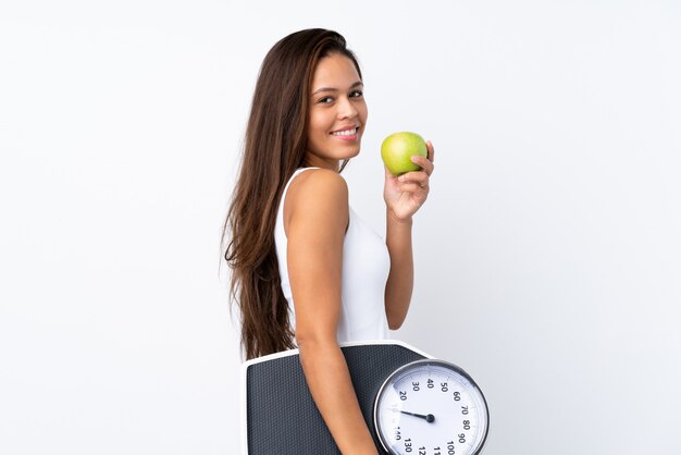 Young Brazilian woman with a scale and an apple