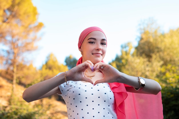 Foto giovane sopravvissuta al cancro al seno che si tiene per mano simbolo del cuore