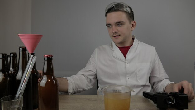 A young brewer prepares products and checks the quality of the equipment and the quality of honey beer brewed at home