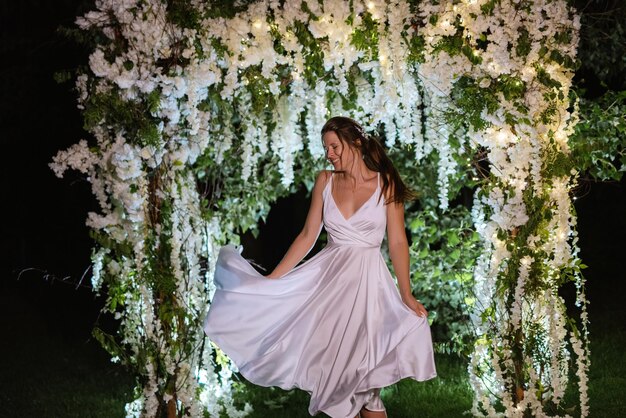 Young bride on the evening illuminated arch